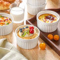 White ramekin bowls with fruit and custard toppings