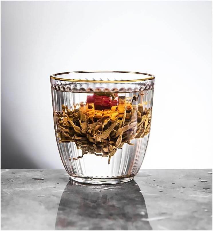Blooming tea in clear water inside a Retro Striped Glass Cup