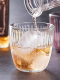 Whiskey poured into a Textured Glass Tumbler with ice cubes