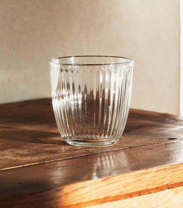Retro Striped Glass Cup catching warm sunset light on wood