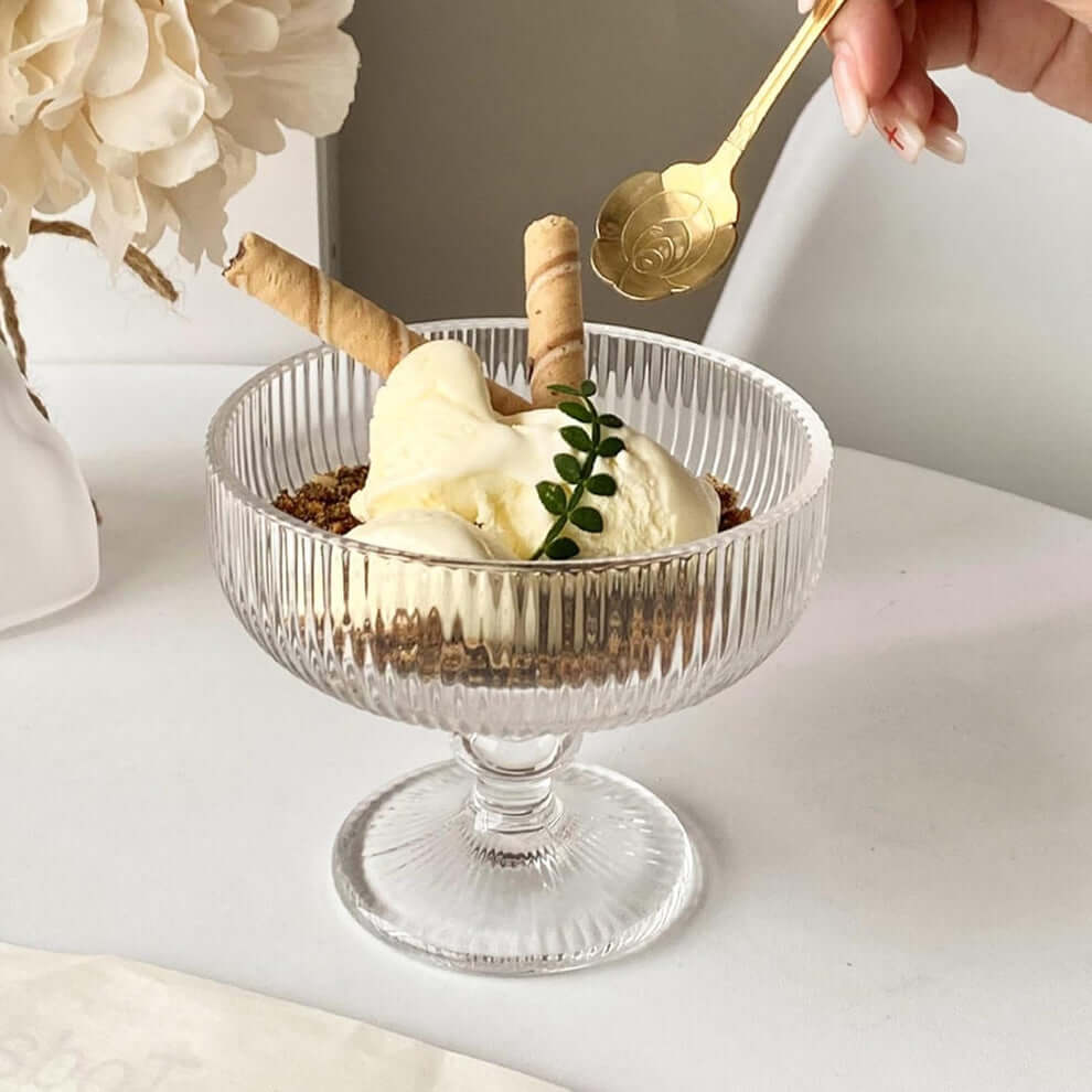 Glass dessert bowl with layered treat and rolled wafers