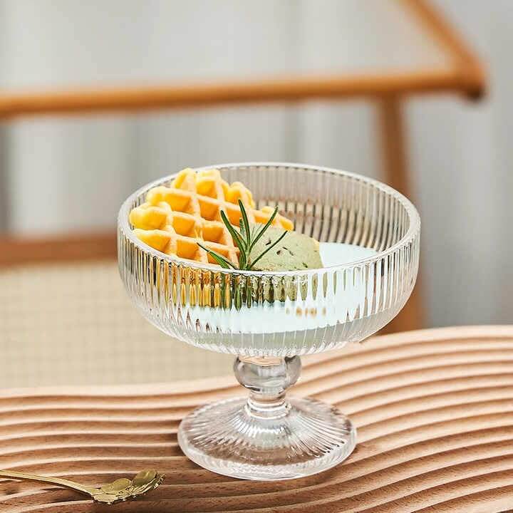 Glass dessert bowl with layered treat and rolled wafers